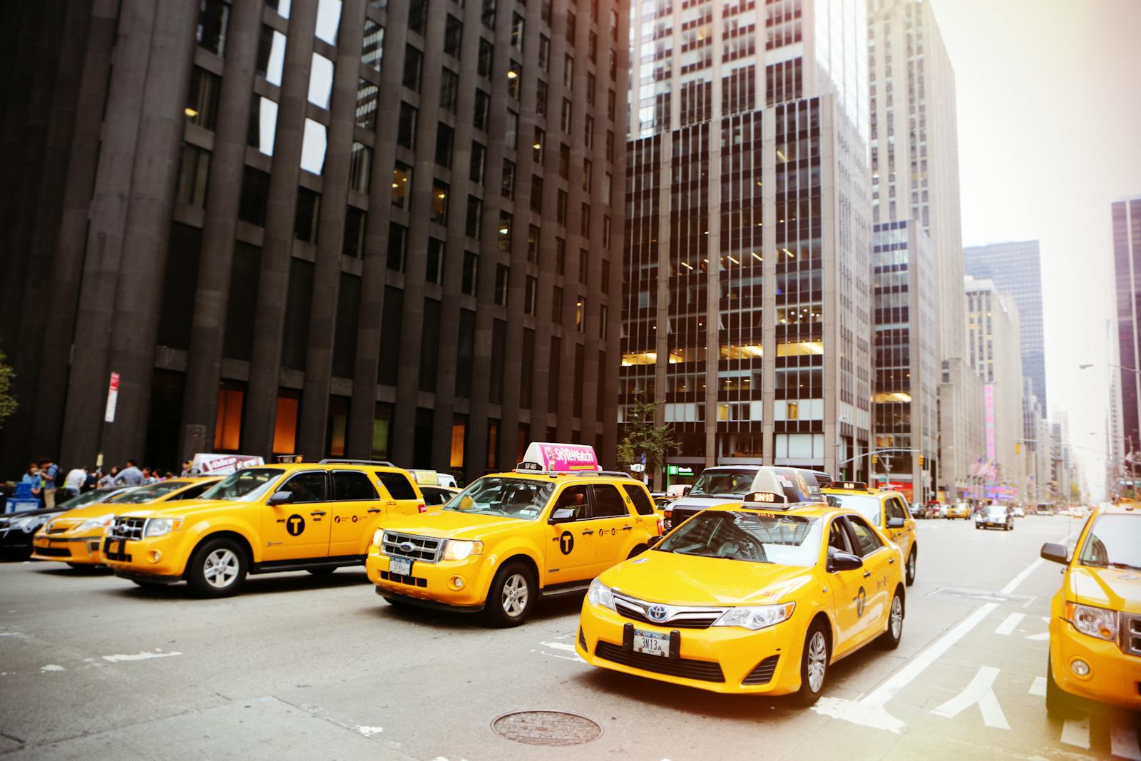 Street scene with yellow taxis in New York City, iconic urban traffic captured in daylight.